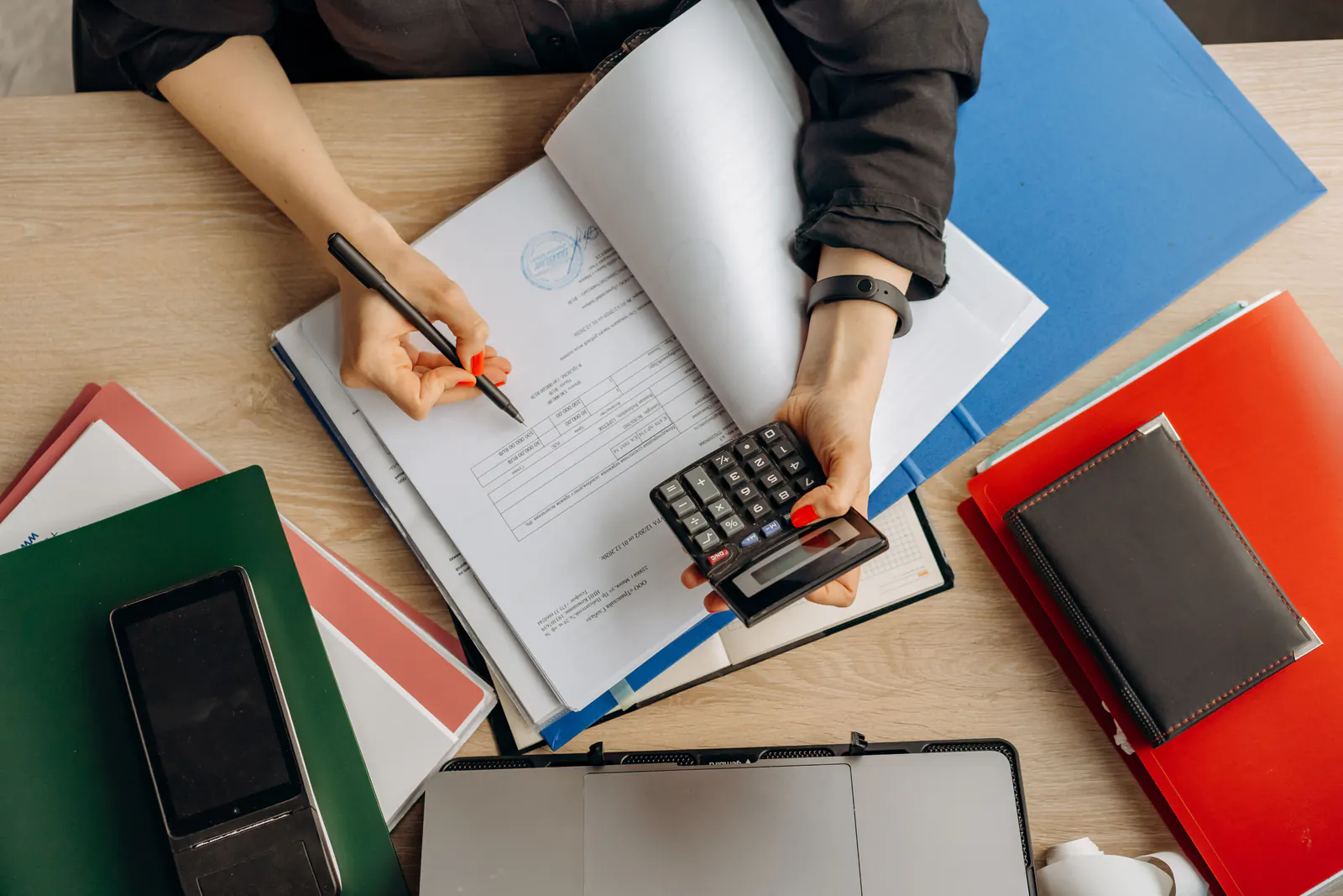 Accountant reviewing financial records with a calculator
