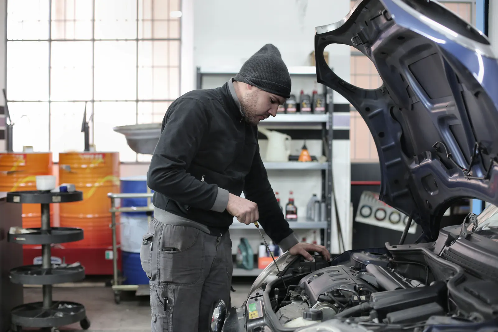 Auto repair technician inspecting an engine in a service bay