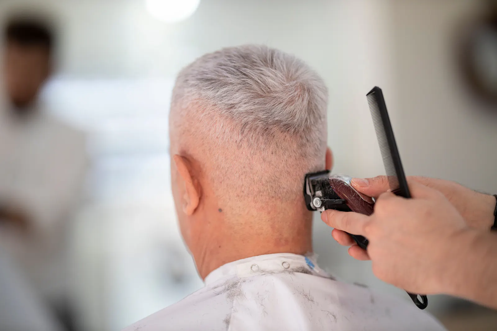 Barber giving a client a close clipper haircut