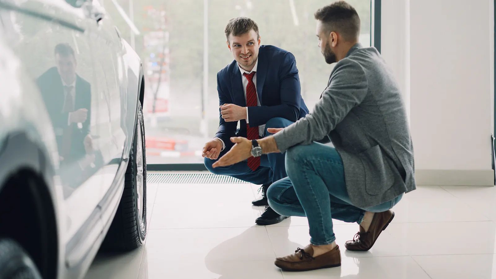 Car dealership salesperson showing a vehicle to a customer