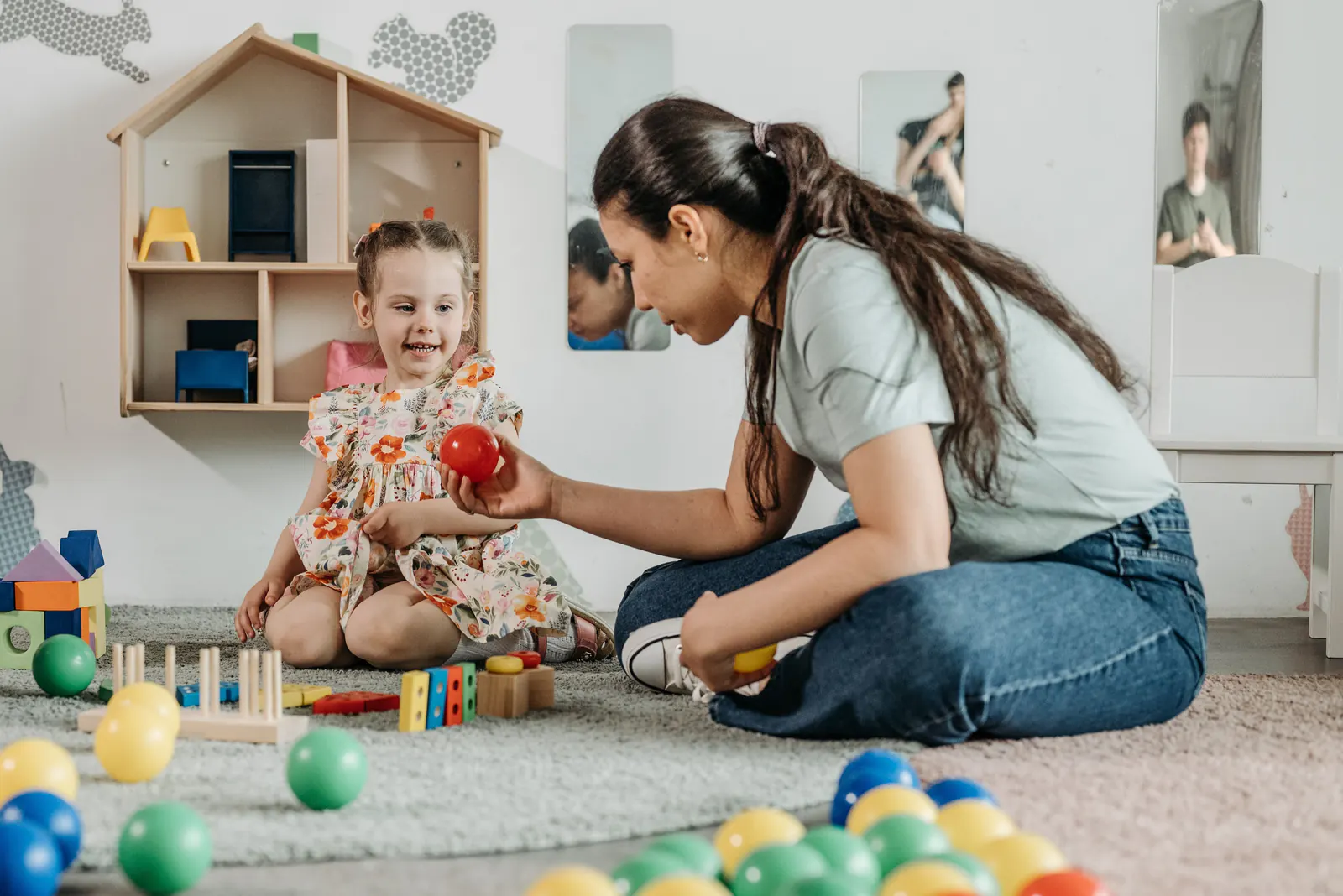 Child care provider playing with a young child in a learning center