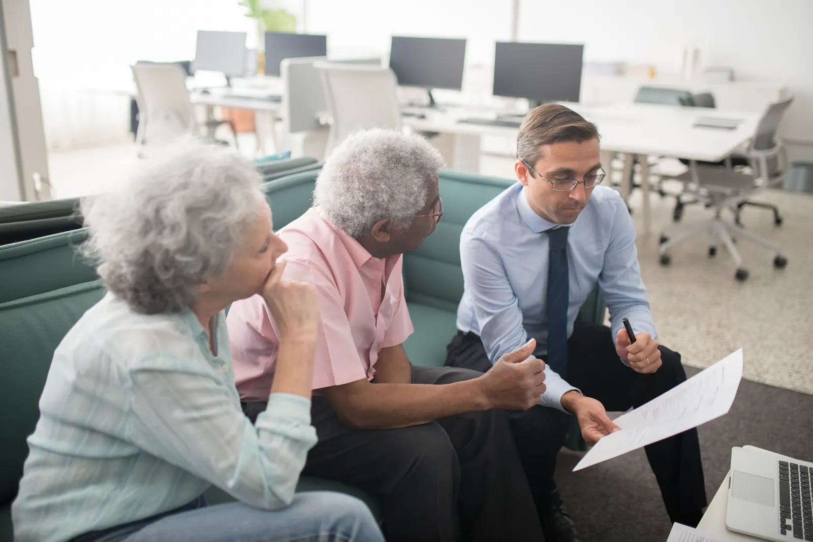 Financial advisor reviewing documents with a retired couple