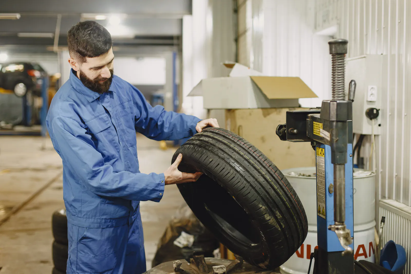 Tire shop technician mounting a new tire